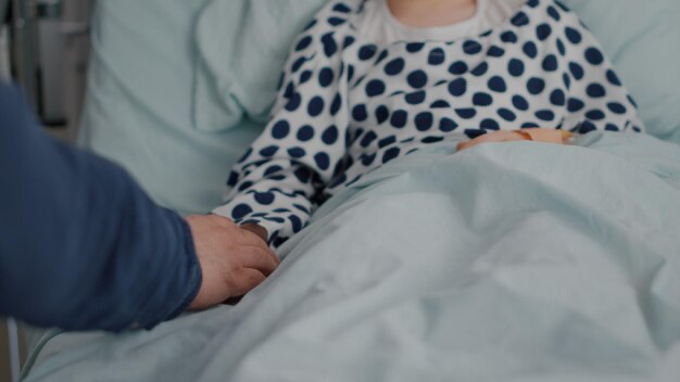 Man holding woman's hand in hospital