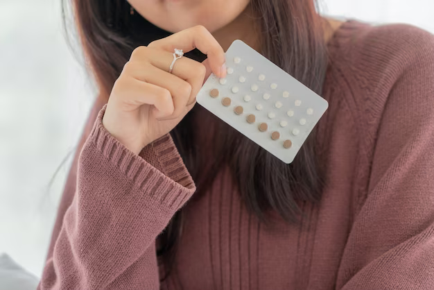 A woman is holding birth control pills